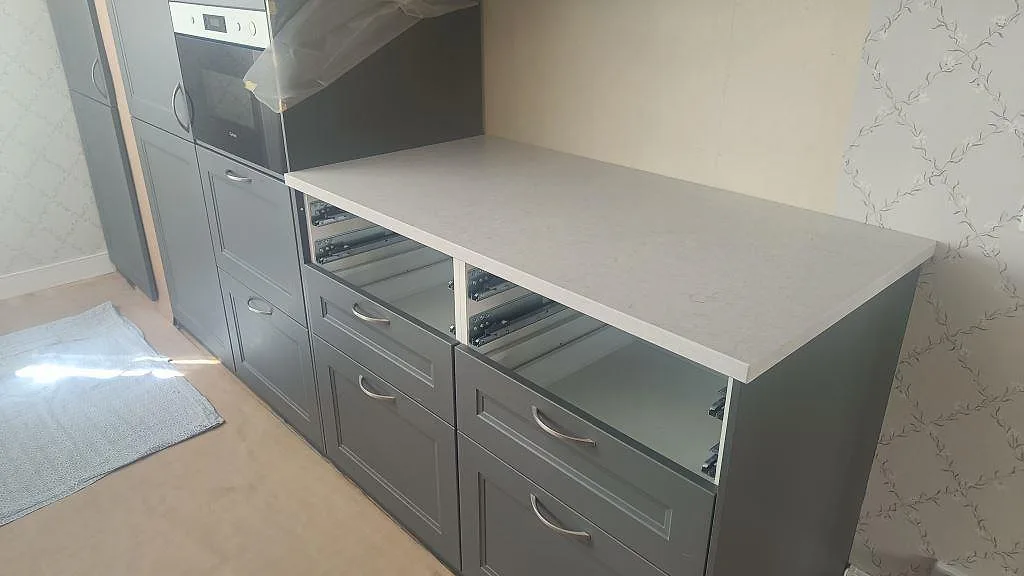 Rak köksbänkskiva i Silestone Snowy Ibiza, Mocka, på grå köksinredning under montering i Harestad.