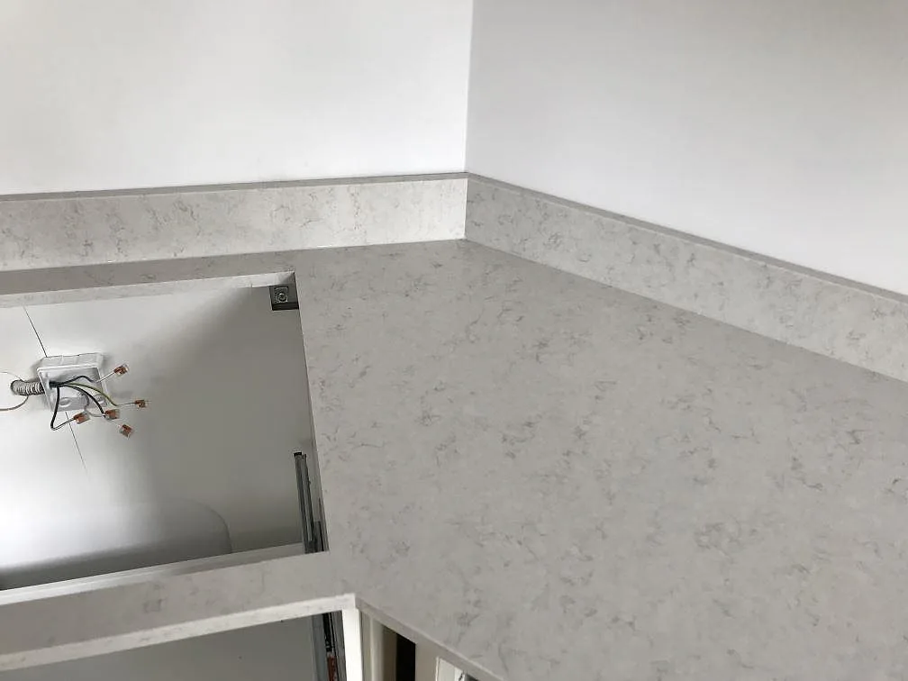 Underlimmad diskho i polerad Silestone Snowy Ibiza köksbänkskiva med förborrade hål för blandare i Helsingborg.