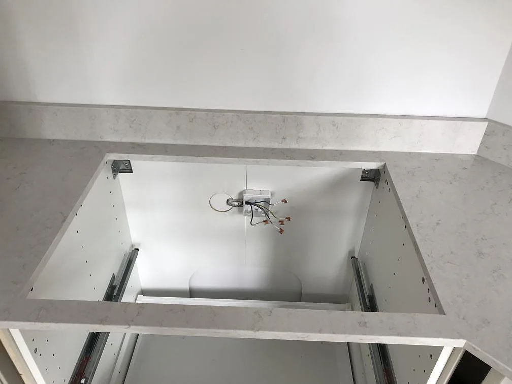 Installerad Silestone Snowy Ibiza köksbänkskiva med urtag och uppvikt stänkkant under montering i ett kök i Helsingborg.