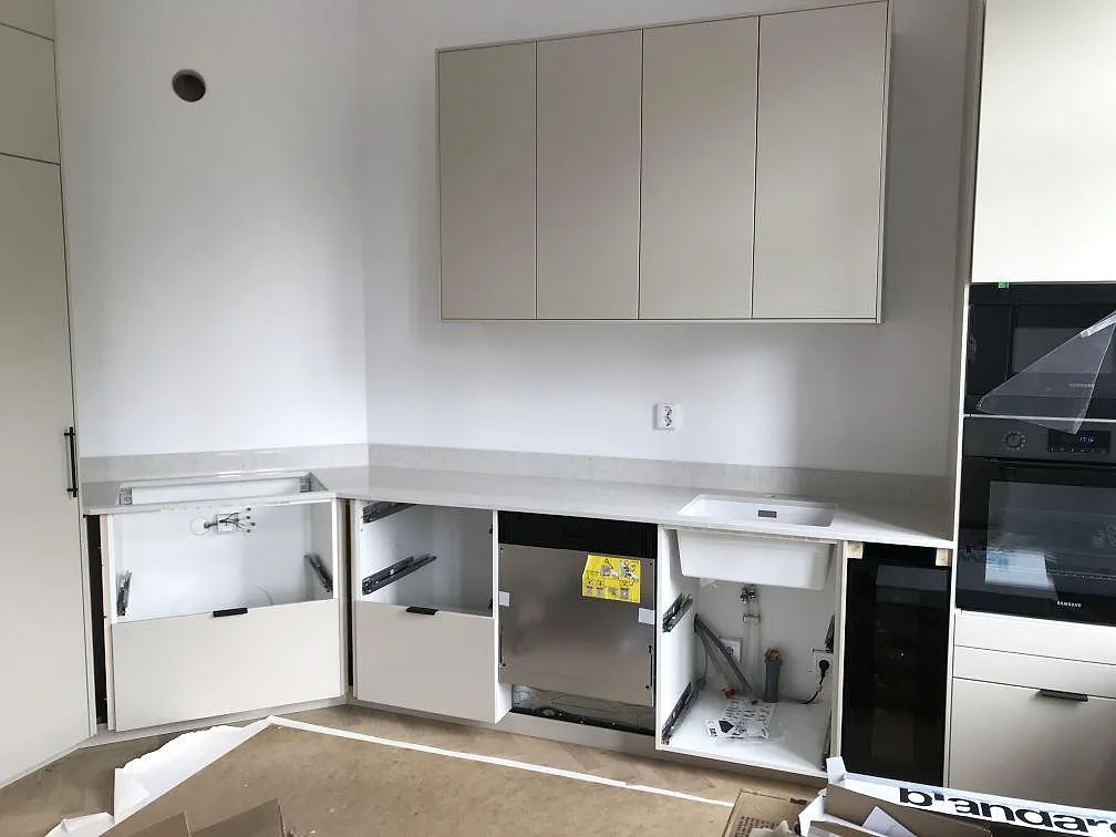 Köksbänkskiva i vit Silestone Snowy Ibiza, polerad, med underlimmad diskho monterad i ett kök i Helsingborg under montering.