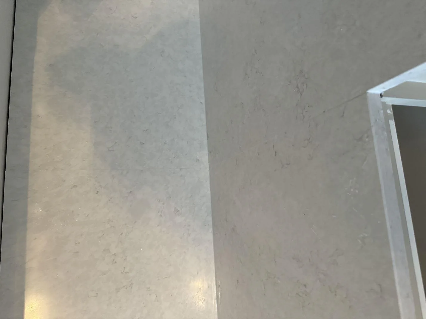 Ytdetalj av polerad Silestone Snowy Ibiza komposit där bänkskiva möter väggbeklädnad i Helsingborg.