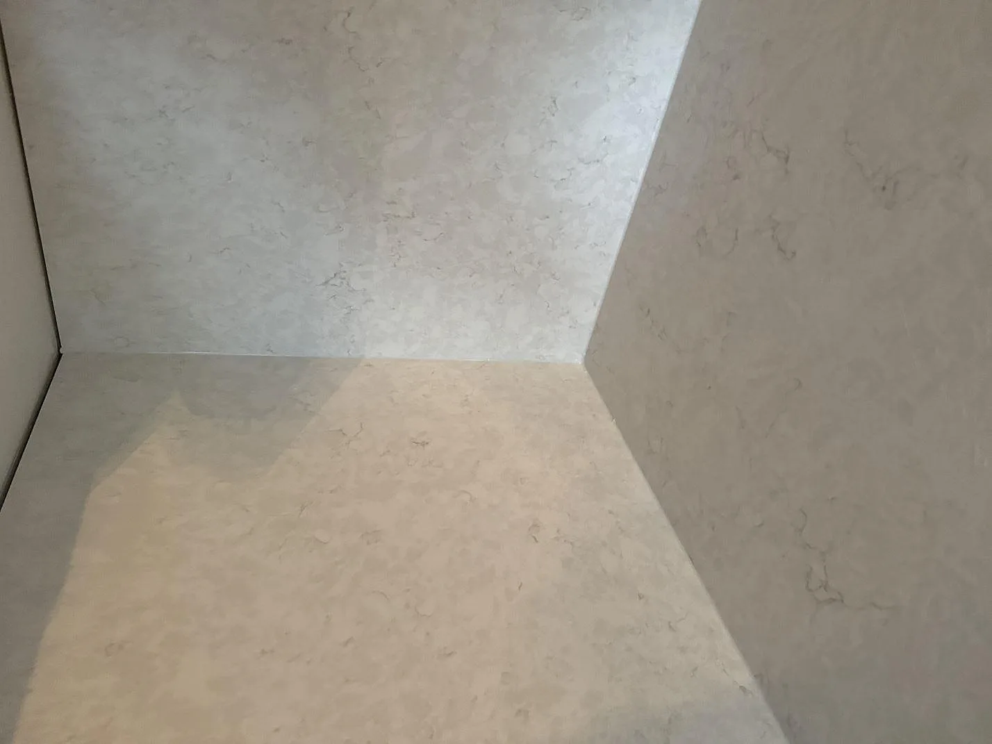 Detalj av hörn med polerad Silestone Snowy Ibiza som bänkskiva och väggbeklädnad i ett kök i Helsingborg.