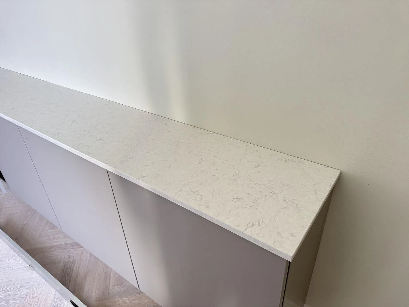 Lång köksbänkskiva i Silestone Snowy Ibiza, 20 mm polerad komposit, på ljusa köksstommar i Helsingborg.