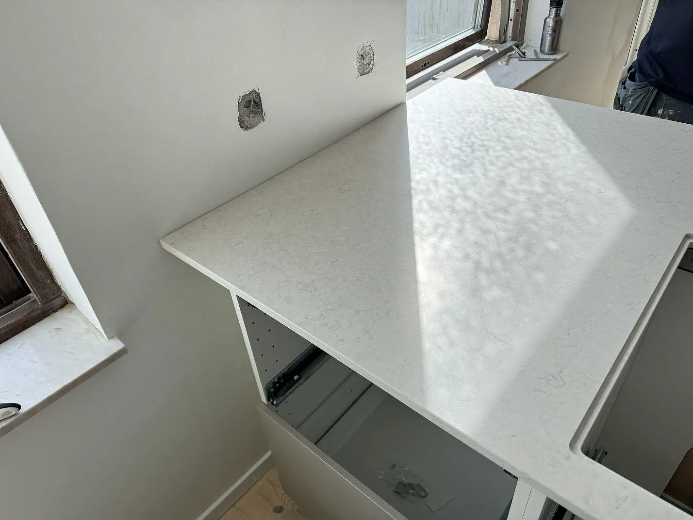 Sidovy av Silestone Snowy Ibiza Mocka på köksbänk vid fönster, med matt komposityta under montering i Helsingborg.