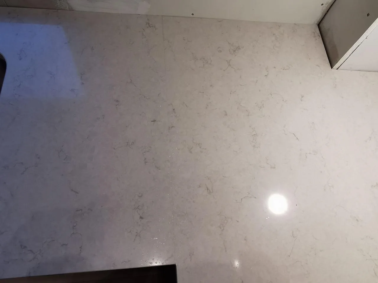 Installerad bänkskiva i polerad Silestone Snowy Ibiza med synlig skarv mellan skivorna i ett kök i Hindås.