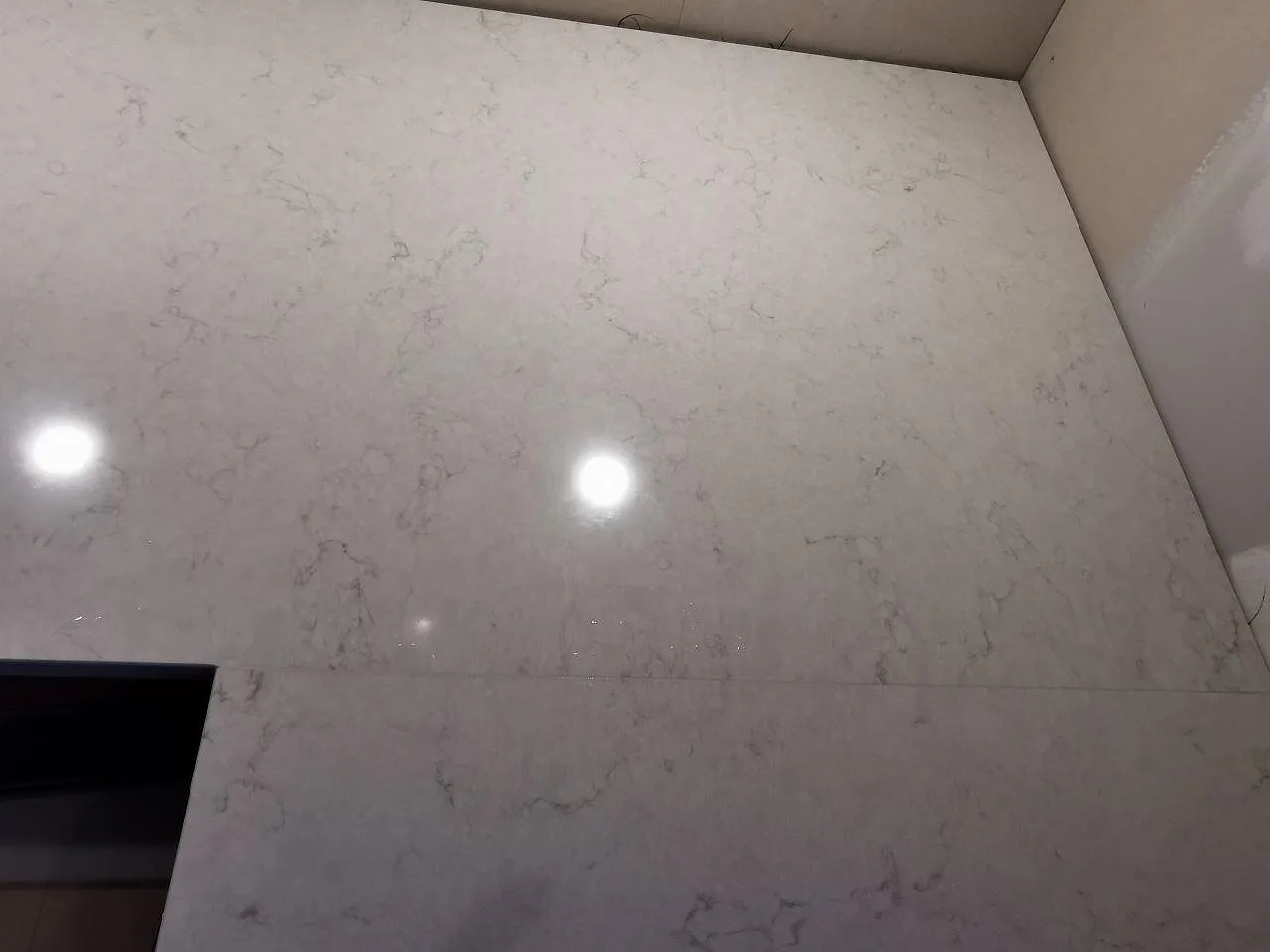 Hörnparti av köksbänkskiva i polerad Silestone Snowy Ibiza i ett kök i Hindås.