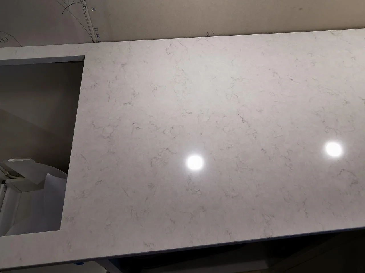 Köksbänkskiva i Silestone Snowy Ibiza med urtag för häll, polerad vit kvartskomposit i ett kök i Hindås.