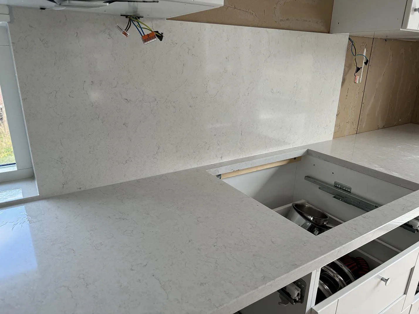 Hällöppning i polerad Silestone Snowy Ibiza med matchande stänkskydd och ljusa köksstommar i Hisings Kärra.