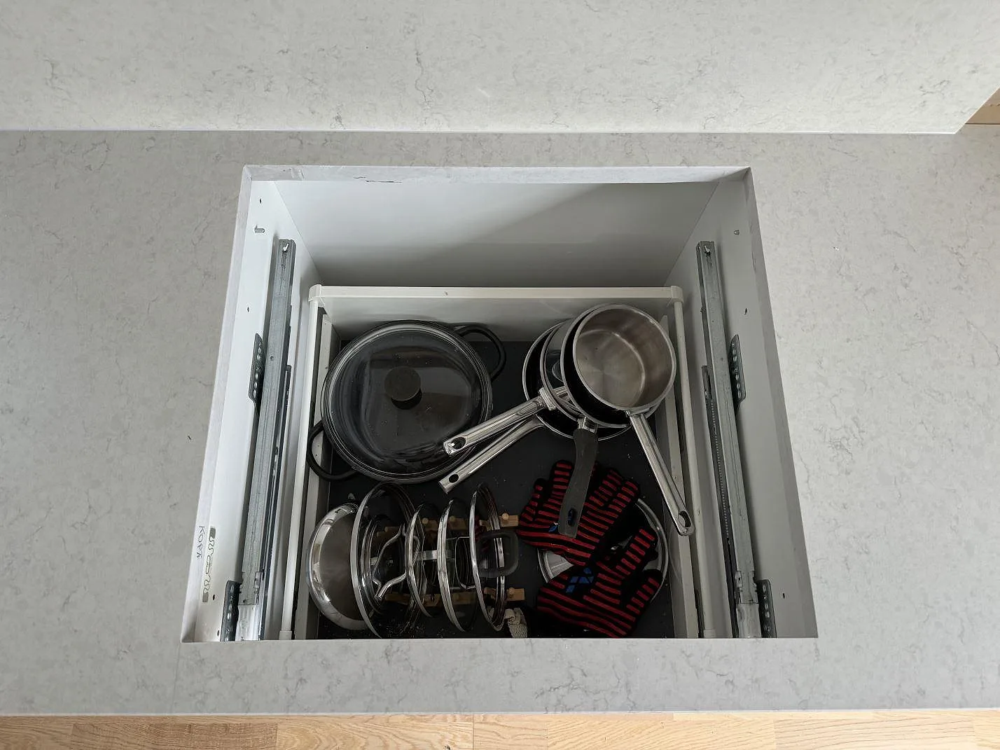 Detalj av hällöppning och polerad Silestone Snowy Ibiza bänkskiva i komposit ovanför köksstomme i Hisings Kärra.