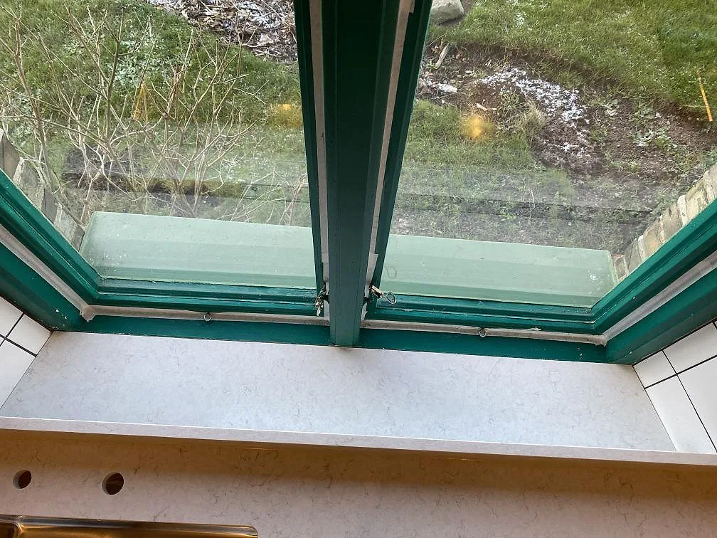 Fönsternisch och låg stenkant i polerad Silestone Snowy Ibiza, vit kvartskomposit ovanför köksbänk i Höganäs.