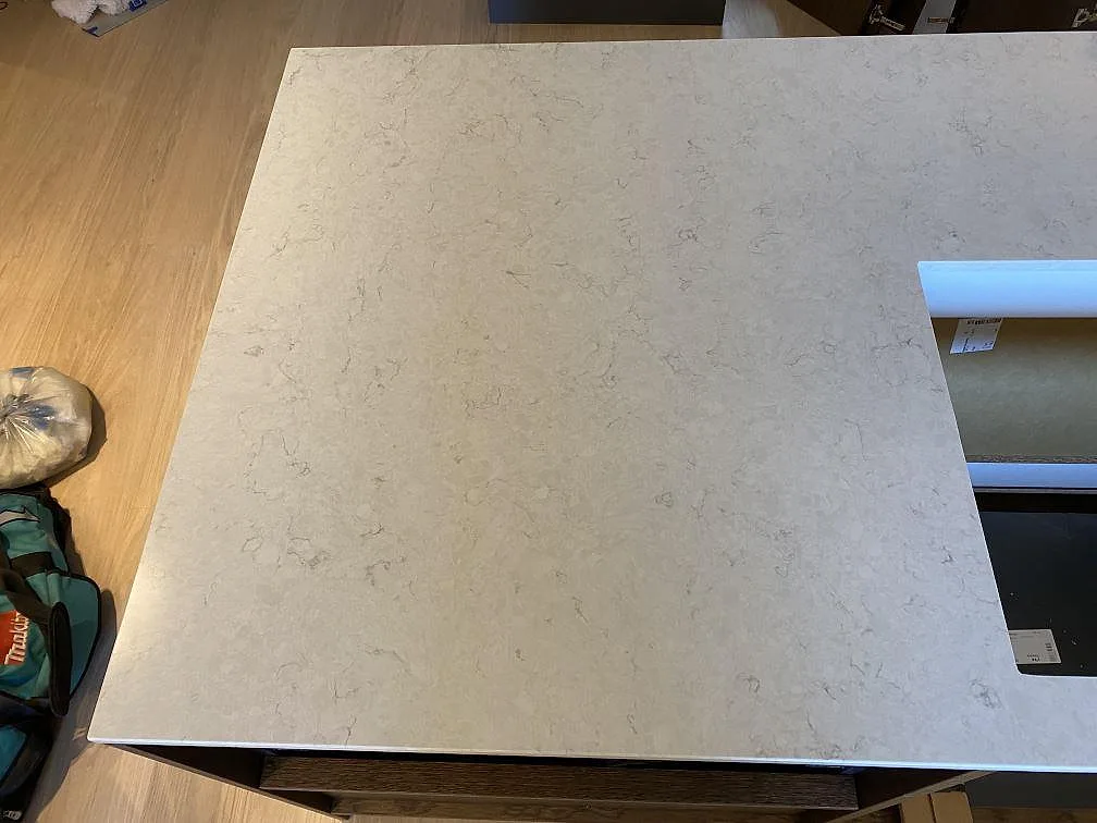 Topvy av den polerade kvartskompositen Silestone Snowy Ibiza med diskret grå ådring och kant mot hällurtag i köket i Höllviken.