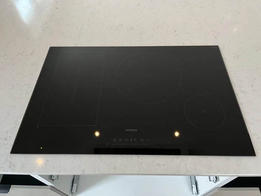 Induktionshäll infälld i en köksbänkskiva av Silestone Snowy Ibiza, vit kvartskomposit, i ett kök i Hönö.