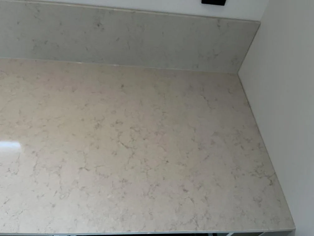 Bänkyta i Silestone Snowy Ibiza med uppvikt stänkkant, ljus kvartskomposit, sedd ovanifrån i ett kök i Hönö.