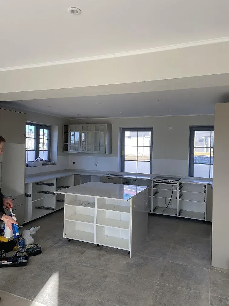 Ljust kök i Höör under montering med halvö och köksö i vit Silestone Snowy Ibiza framför stora fönster.