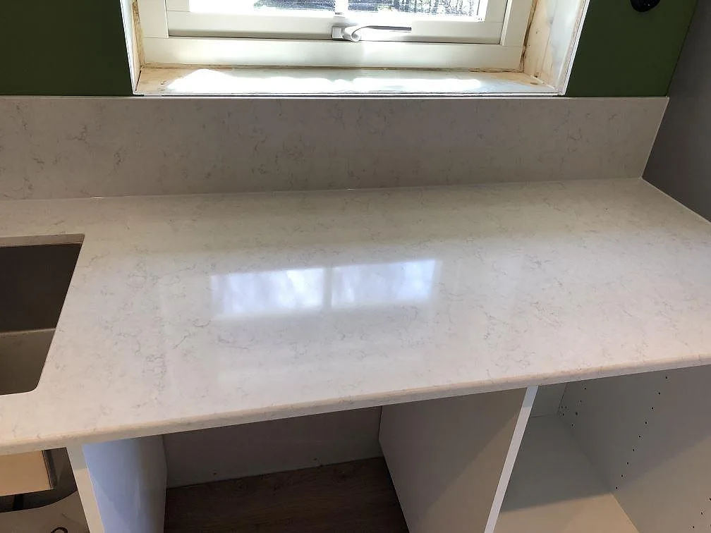 Fönsterbänk i vit Silestone Snowy Ibiza med fin grå ådring vid fönstret i ett kök i Hörby.