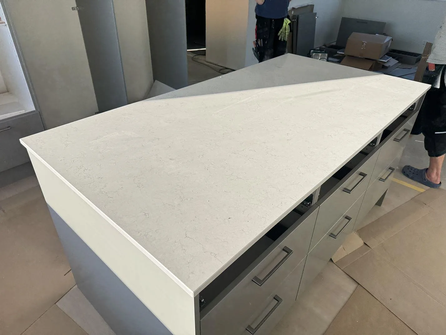 Arbetsyta i polerad Silestone Snowy Ibiza med låg stänkkant och stenklädd fönsterbänk i köket i Holm.
