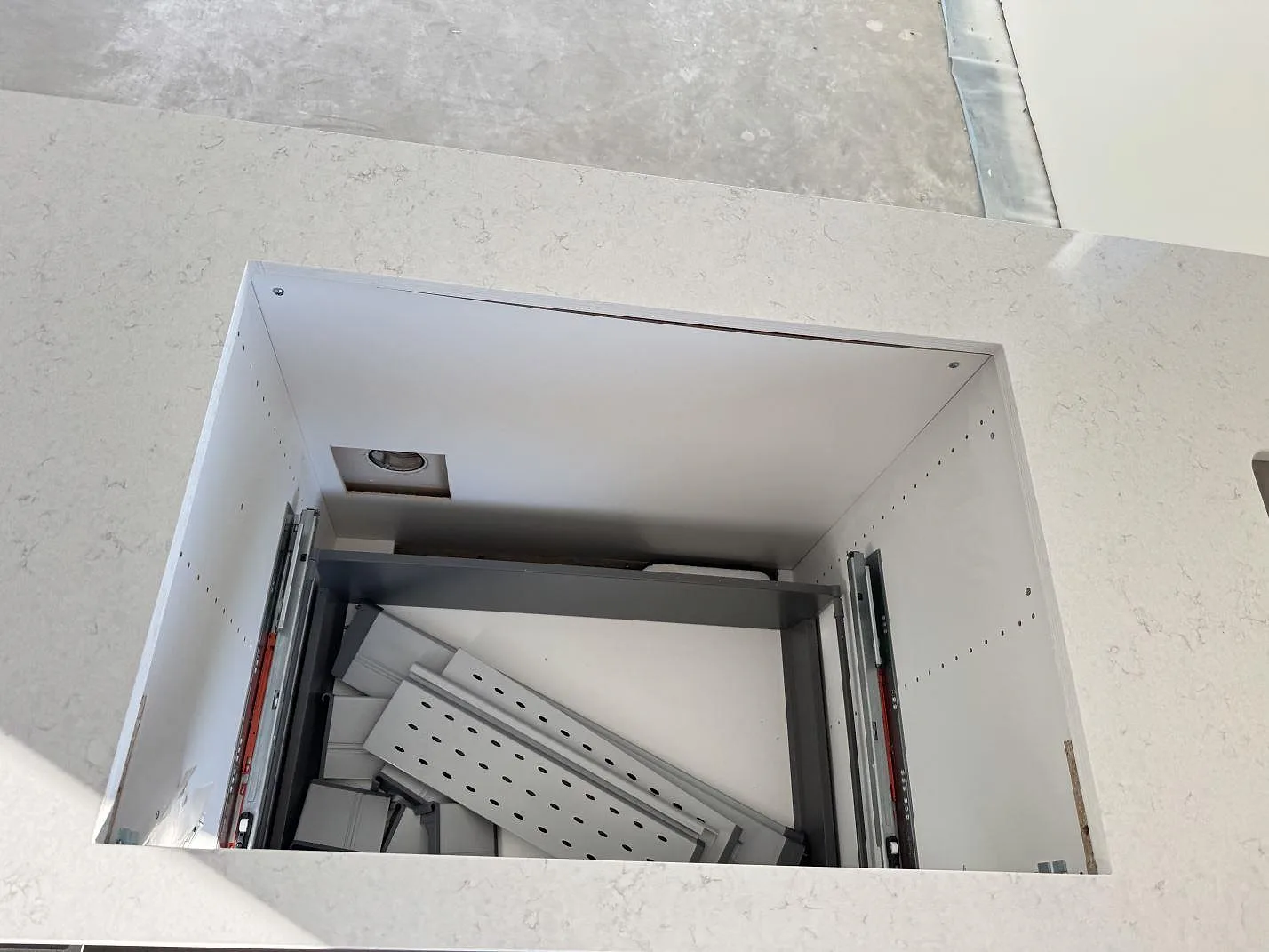 Ovanifrån syns en polerad Silestone Snowy Ibiza bänkskiva runt en öppen köksstomme under montering i Holm.