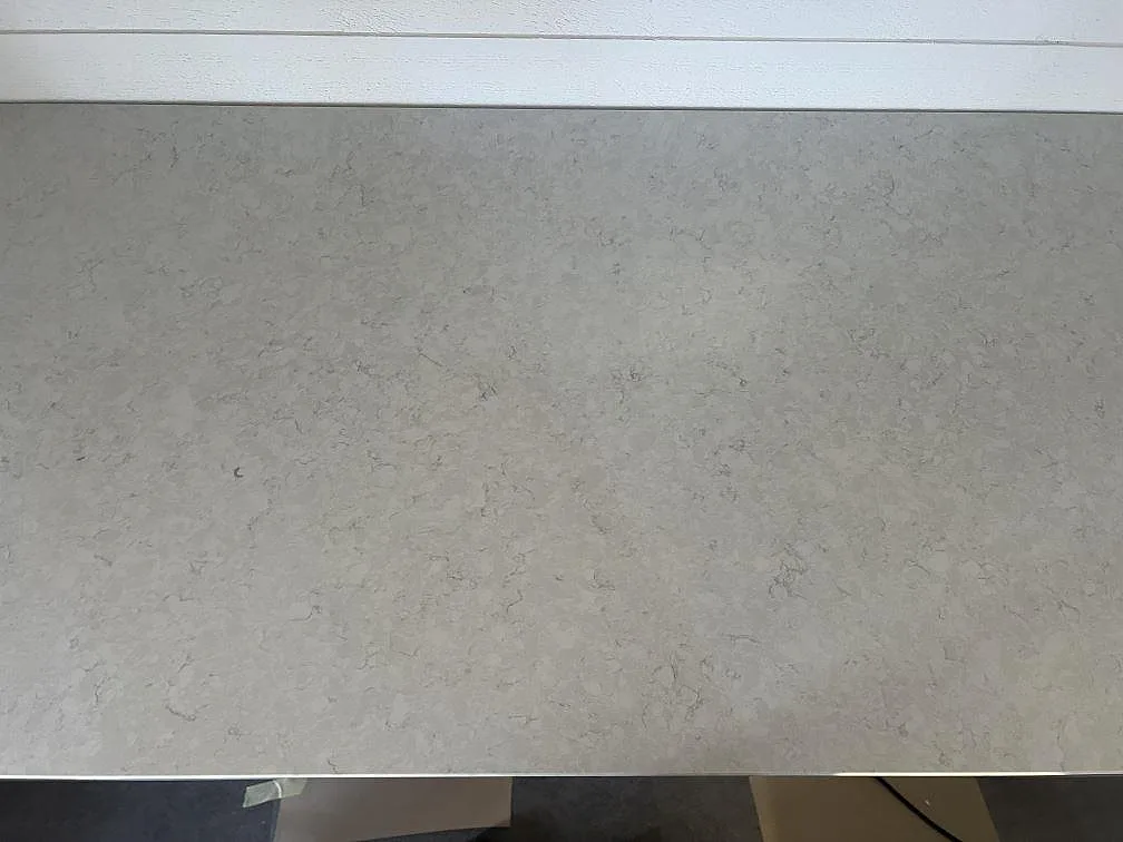 Detaljbild av den polerade ytan i Silestone Snowy Ibiza komposit, ljus köksbänkskiva med mjuk grå ådring i Hovmantorp.