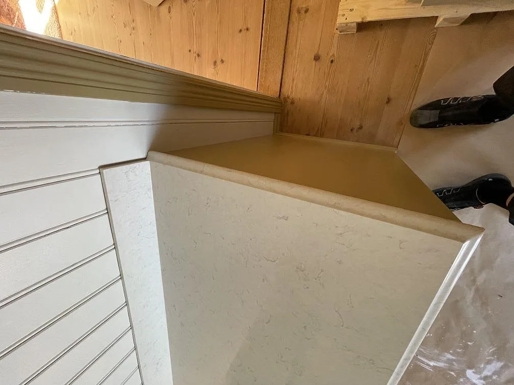 Underlimmad vit diskho med drillat blandarhal i en polerad koksbankskiva i Silestone Snowy Ibiza med gra adring i ett kok i Hudiksvall.