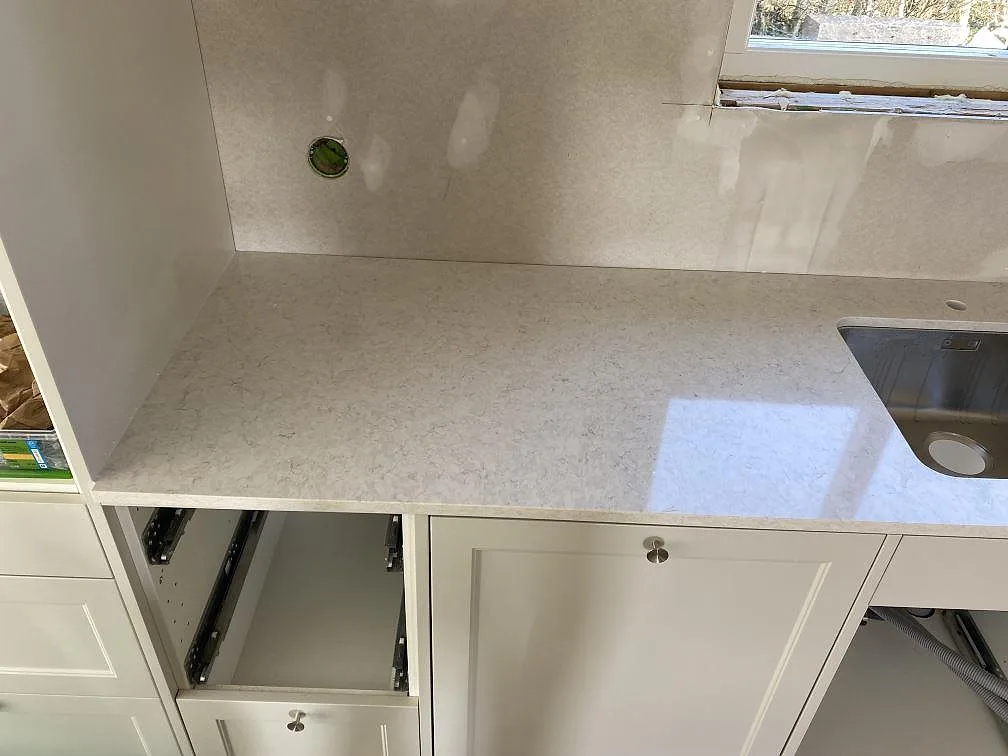 Polerad Silestone Snowy Ibiza bänkskiva med diskho till höger och ljus ådring framför fönster i Hunnebostrand.