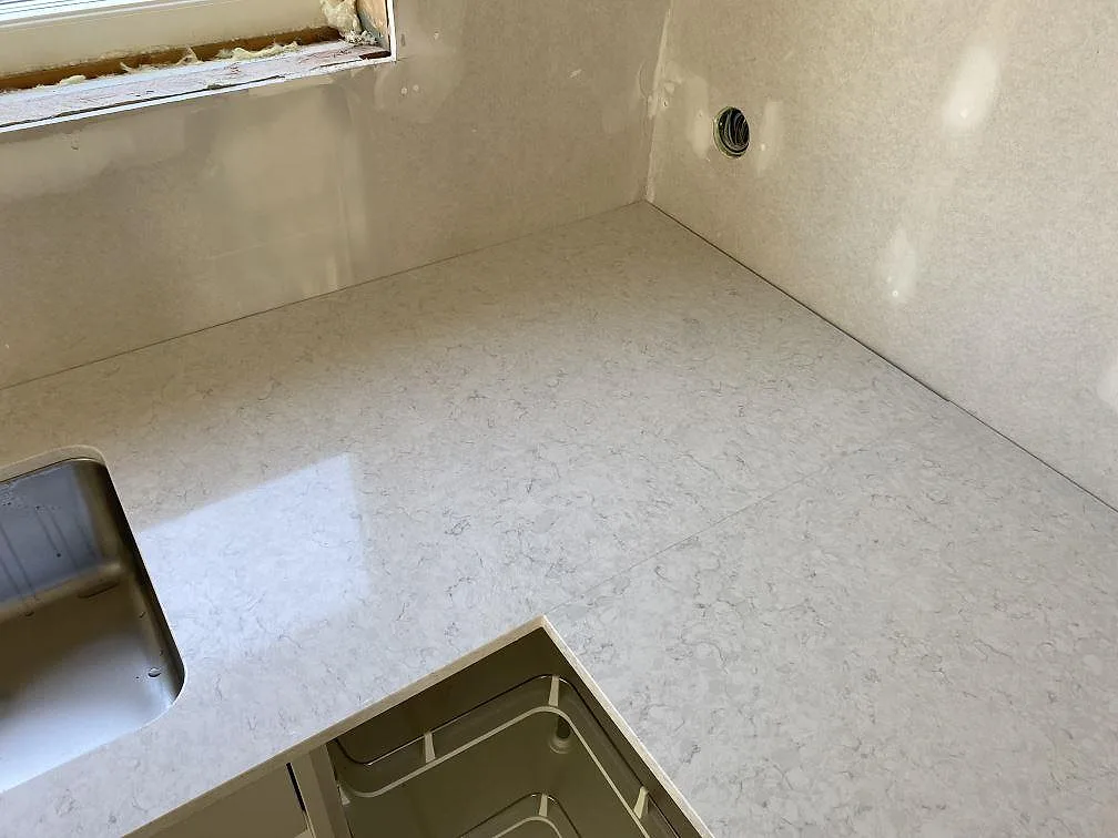Hörndel av köksbänkskiva i polerad Silestone Snowy Ibiza med synlig ljusgrå ådring i Hunnebostrand.
