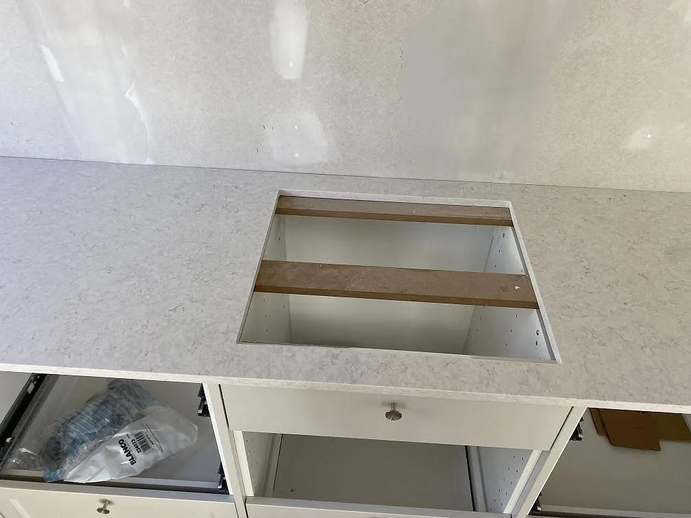 Detalj av hällöppningen i en polerad kompositbänkskiva av Silestone Snowy Ibiza i köket i Hunnebostrand.