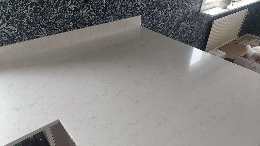 Närbild på polerad Silestone Snowy Ibiza med uppvikt stenkant och utskärning i köksbänkskiva i Huskvarna.