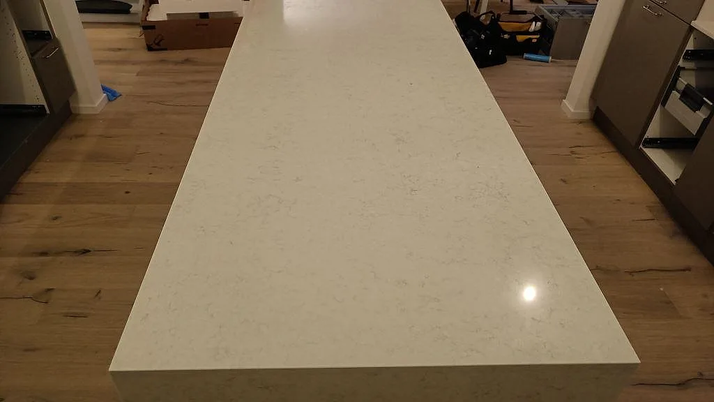 Köksöns ovansida i polerad Silestone Snowy Ibiza i ett kök under montering i Kivik.