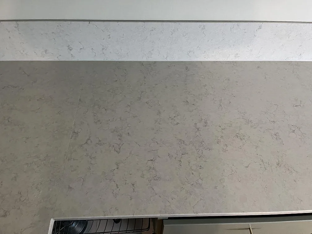 Silestone Snowy Ibiza bänkskiva i kök med uppvikt stänkkant i samma vita kvartskomposit i Klagshamn.