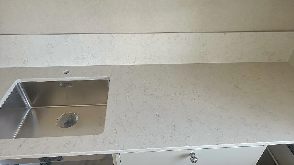 Underlimmad rostfri diskho och uppvikt stänkskydd i vit Silestone Snowy Ibiza köksbänkskiva i Klippan.