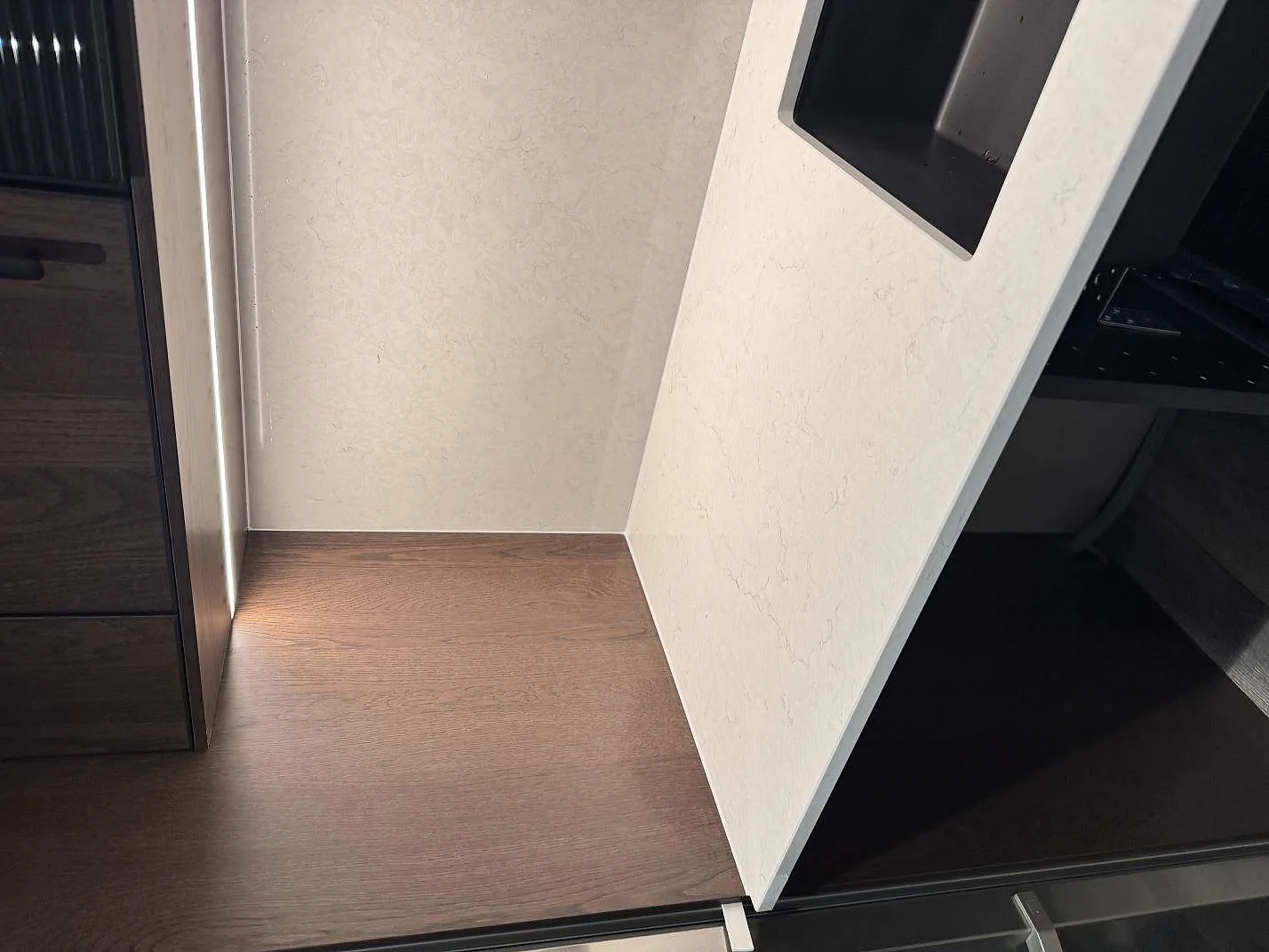 Uppvikt stänkkant i vit Silestone Snowy Ibiza med infälld eluttagsbox vid bänkraden i ett kök i Klippan.