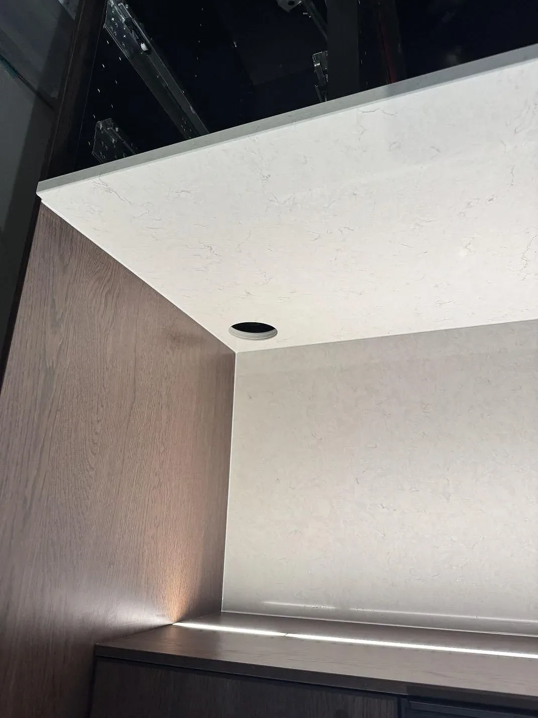 Närbild på uppvikt kant och kran-/blandarhål i polerad vit Silestone Snowy Ibiza i ett kök under montering i Klippan.