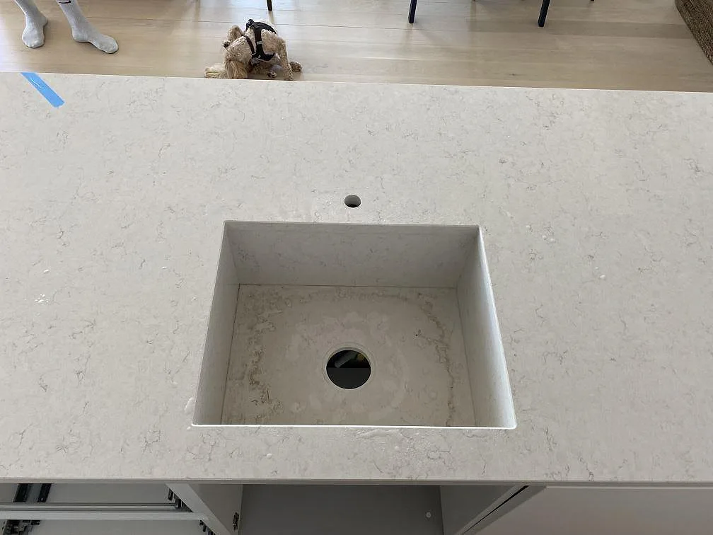 Öppning för ho och blandare i en polerad köksbänkskiva av Silestone Snowy Ibiza på köksön i ett kök i København V.