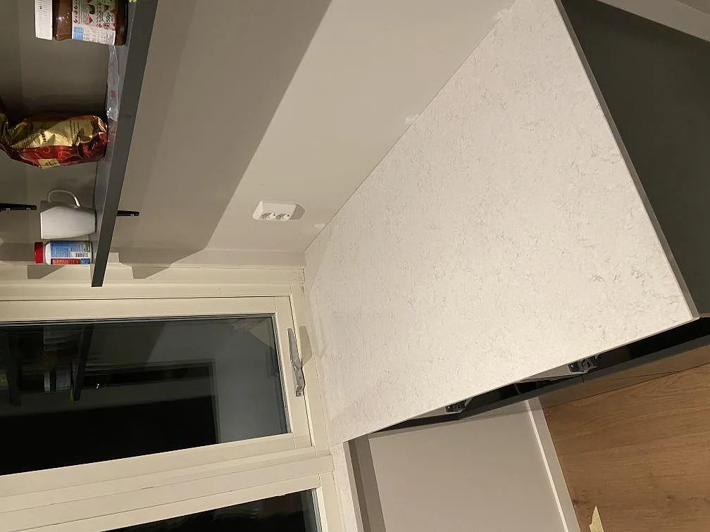Detalj av stänkskydd och nisch i vit Silestone Snowy Ibiza i ett kök i Kullavik.