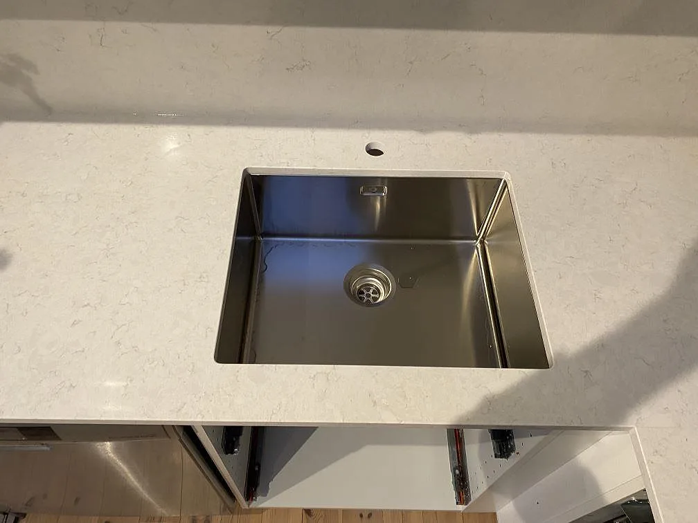 Närbild på polerad Silestone Snowy Ibiza med synlig diskho och låg stänkkant i kök i Kungsbacka.