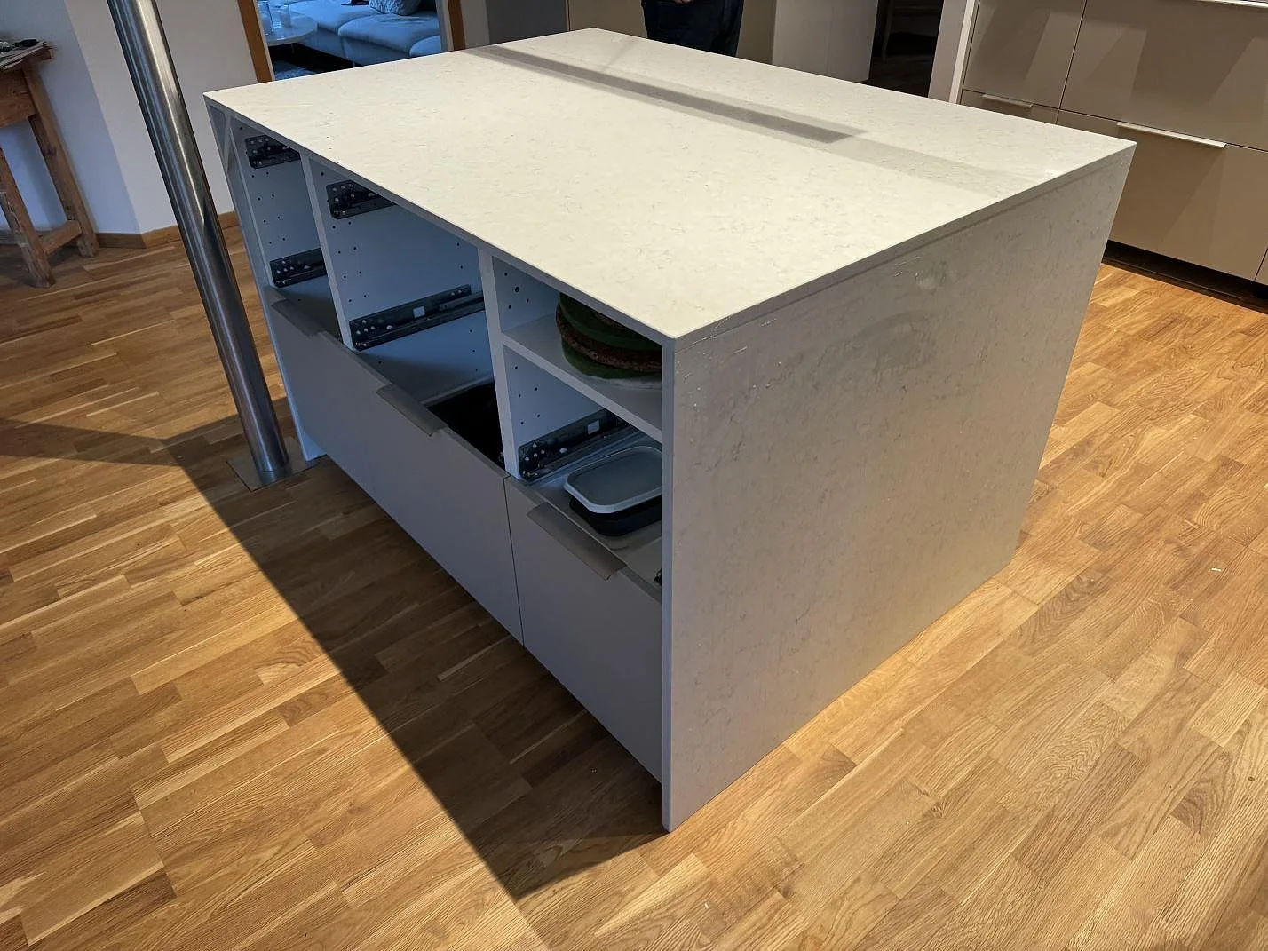 Köksö i polerad Silestone Snowy Ibiza med ljus ådring, stenklädd kortsida och vita köksskåp i Landskrona.