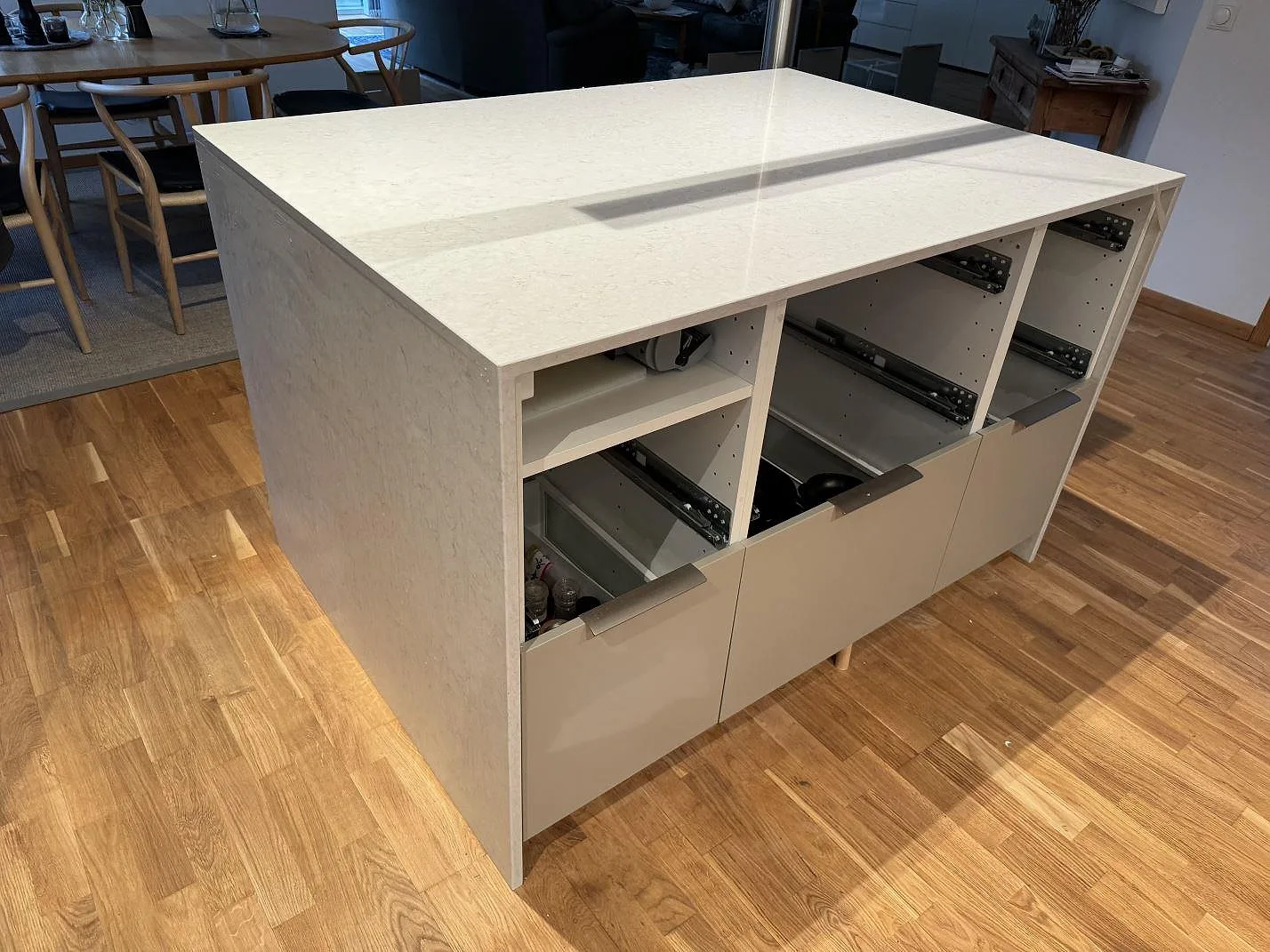 Köksö med bänkskiva och stenklädd sida i 20 mm polerad Silestone Snowy Ibiza, vit kvartskomposit, i ett kök i Landskrona.