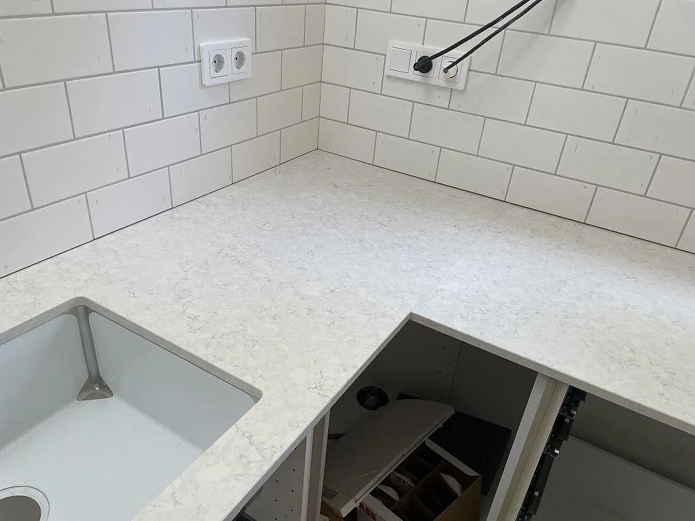 Hörn vid diskho med polerad Silestone Snowy Ibiza som ljus köksbänkskiva i Landvetter.
