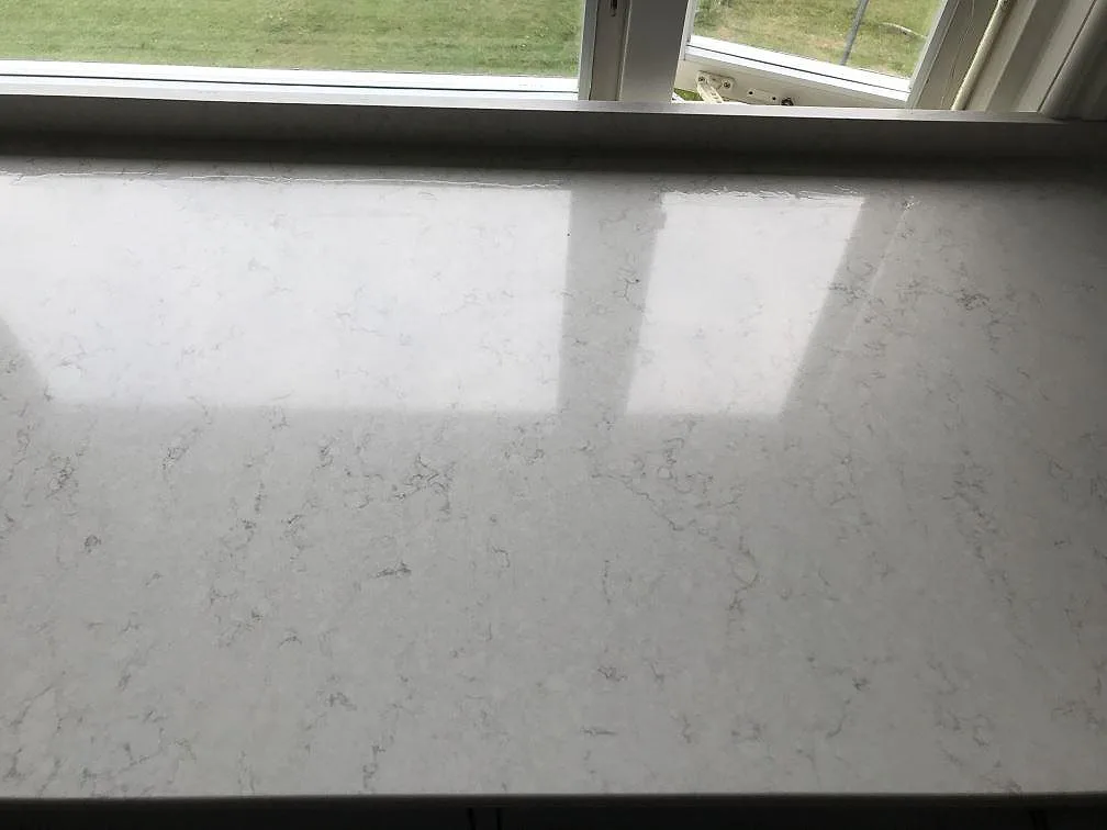 Vit Silestone Snowy Ibiza i fönstersmygen med tydlig spegling i den polerade ytan i ett kök i Lerum.