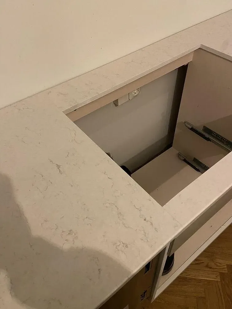 Köksö i polerad Silestone Snowy Ibiza med mjuk grå ådring och urtag för spishäll, sett ovanifrån, i Limhamn.