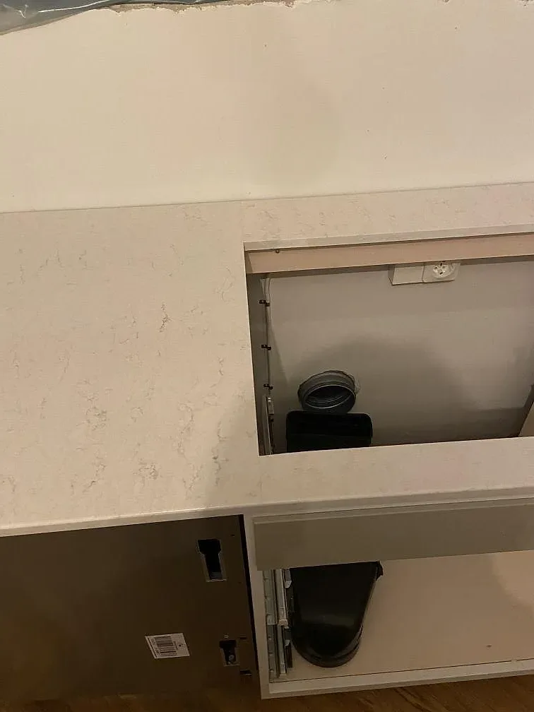 Bänkskiva i polerad Silestone Snowy Ibiza med hällurtag och halvpostad kant i ett kök i Limhamn.