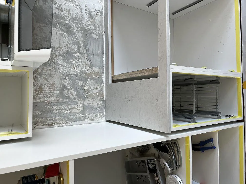 Polerad Silestone Snowy Ibiza koksbankskiva och uppvikt sidogavel i ett kok under installation i Limhamn.