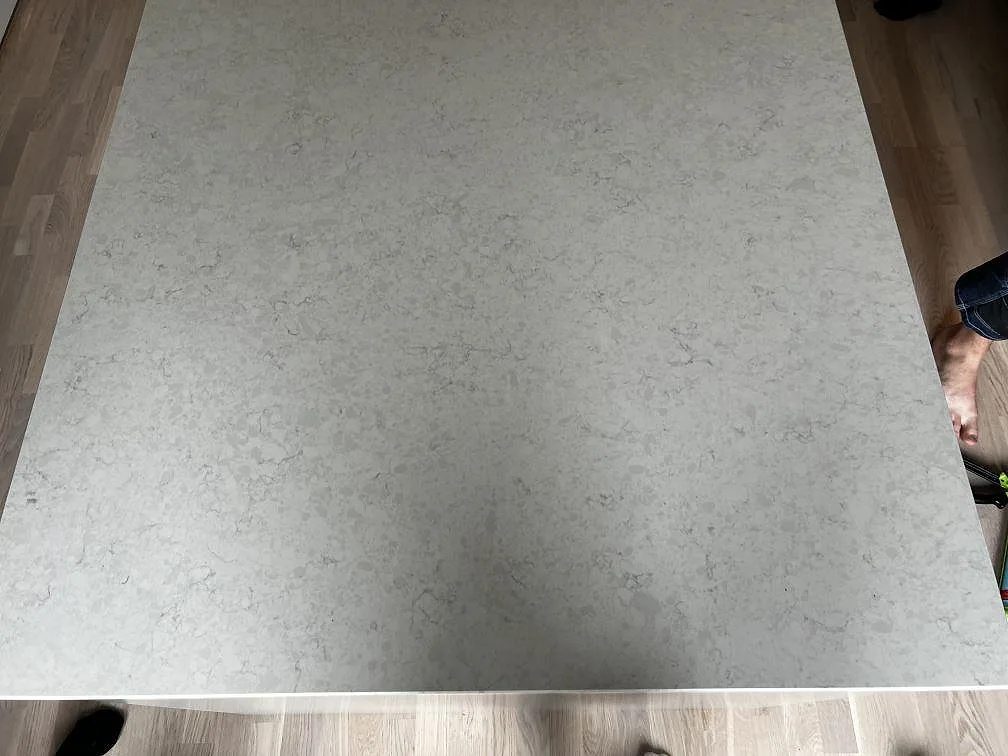 Närbild uppifrån av den polerade Silestone Snowy Ibiza kompositskivan med mjuk grå ådring i Limhamn.