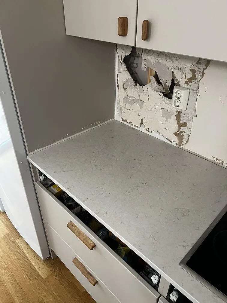 Köksbänkskiva i polerad Silestone Snowy Ibiza vid häll och högskåp under montering i Limhamn.