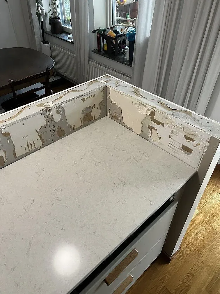 Närbild på polerad Silestone Snowy Ibiza med ljus ådring och uppvikt kant under montering i Limhamn.