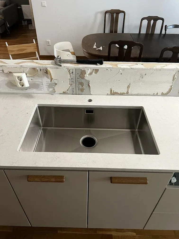 Underlimmad rostfri diskho i en ljus köksbänkskiva av polerad Silestone Snowy Ibiza i Limhamn.
