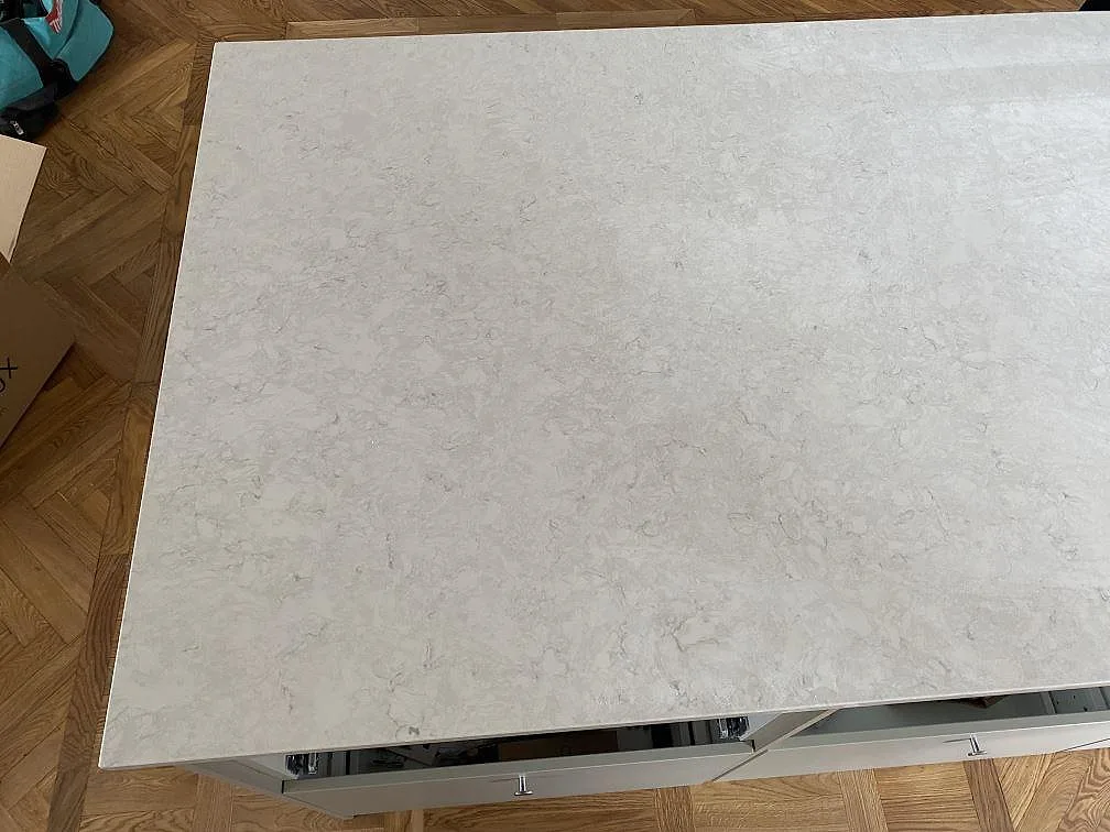 Köksö med stor yta i polerad Silestone Snowy Ibiza, vit kvartskomposit med diskret marmorering i Limhamn.