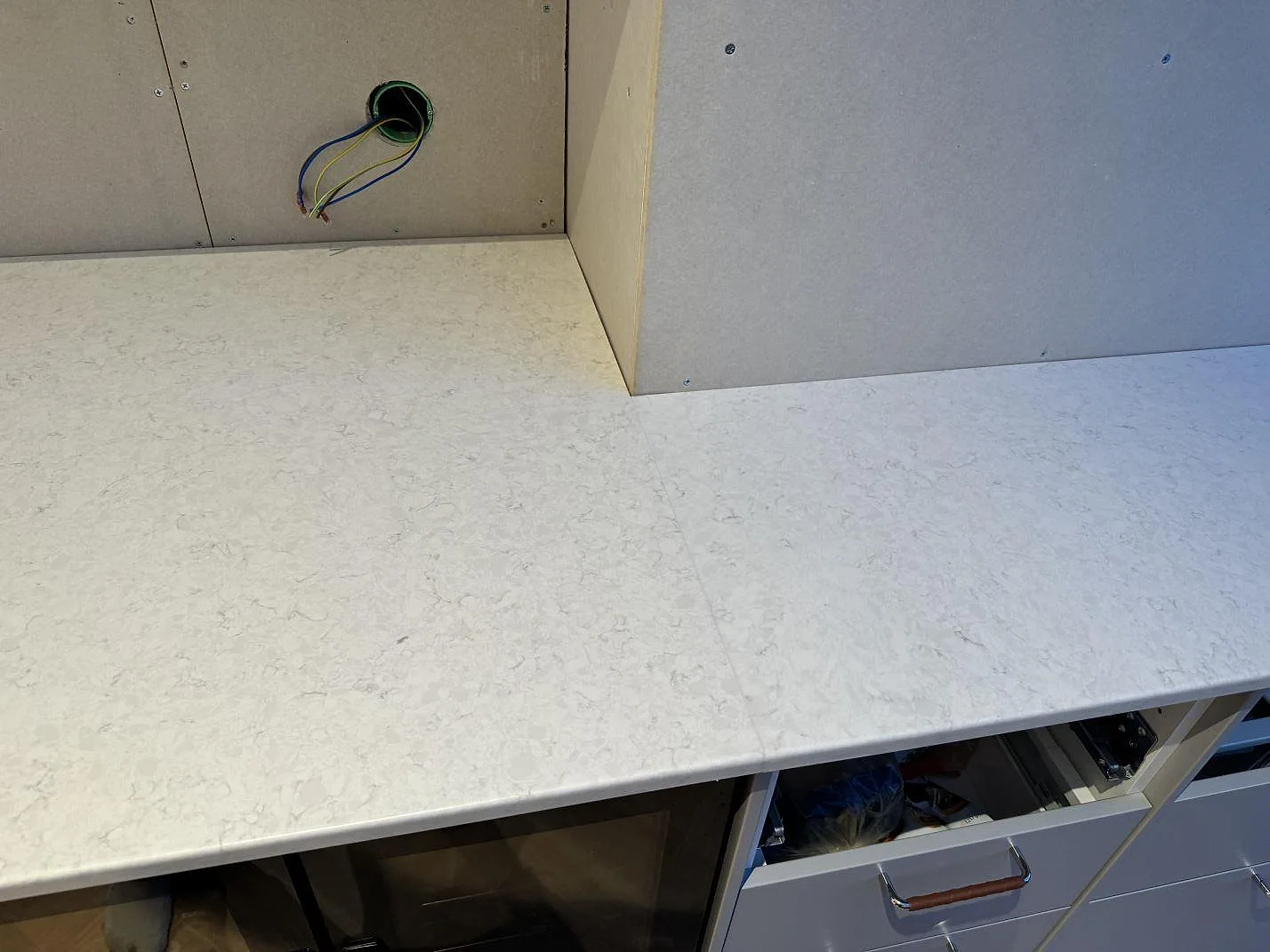 Detalj av skarv och ljus ådring i polerad Silestone Snowy Ibiza på köksbänk under montering i Lindome.