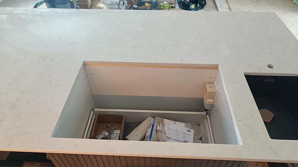 Detalj av hällurtag och svart diskho i 20 mm polerad Silestone Snowy Ibiza på köksö i Löddeköpinge.