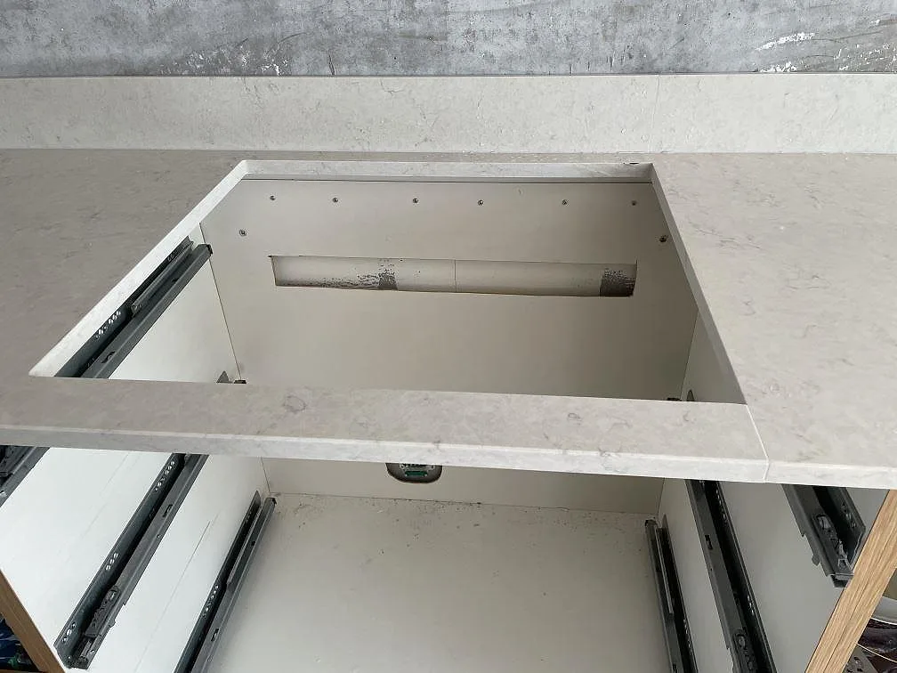 Utsågning för diskho i 20 mm Silestone Snowy Ibiza, polerad kompositsten, under montering i ett kök i Lomma.